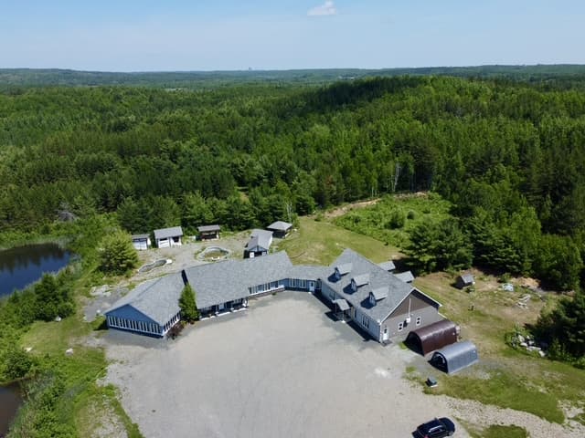 Aerial view of the Roots to Sky property surrounded by forest